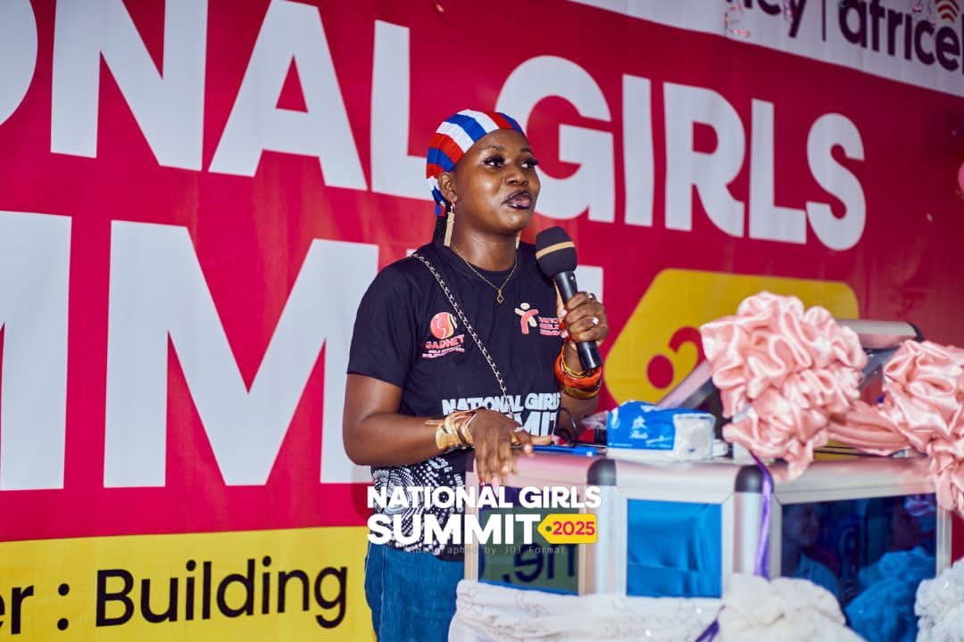 A speaker addressing participants on stage at the National Girls Summit 2025
