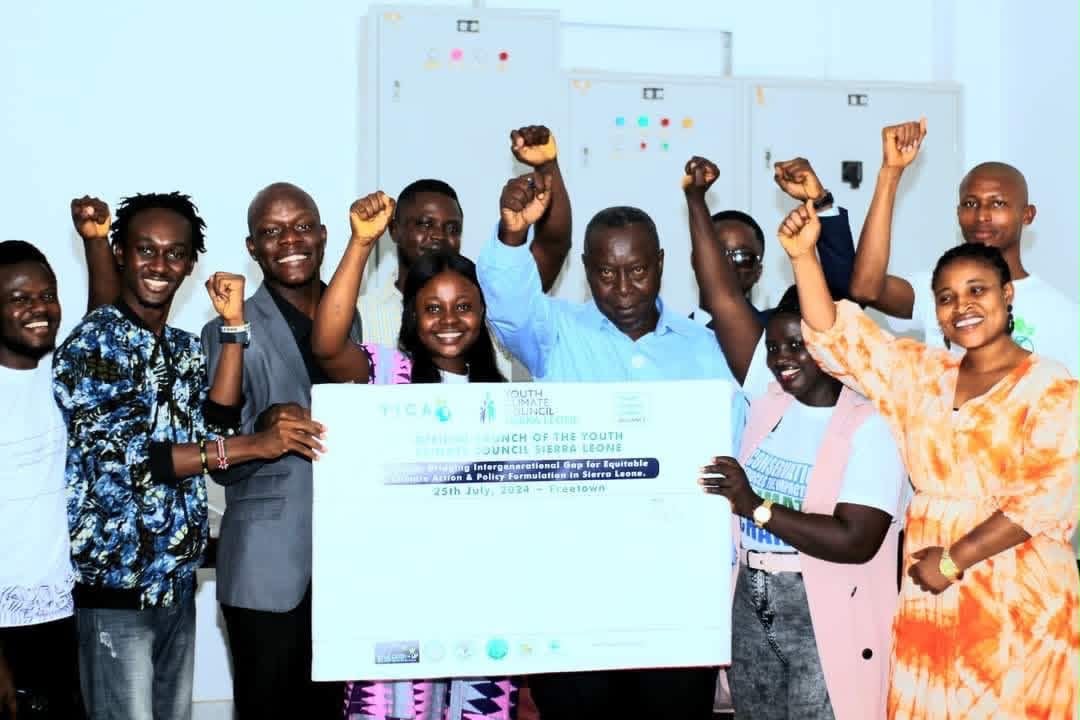 Partner representatives hold the official Youth Climate Council Sierra Leone launch banner in celebration